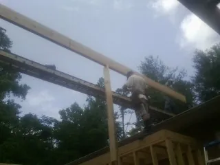 Carpenter setting a ridge beam over a new addition frame — Ice Dam Removal by Roofing Brothers in Monsey