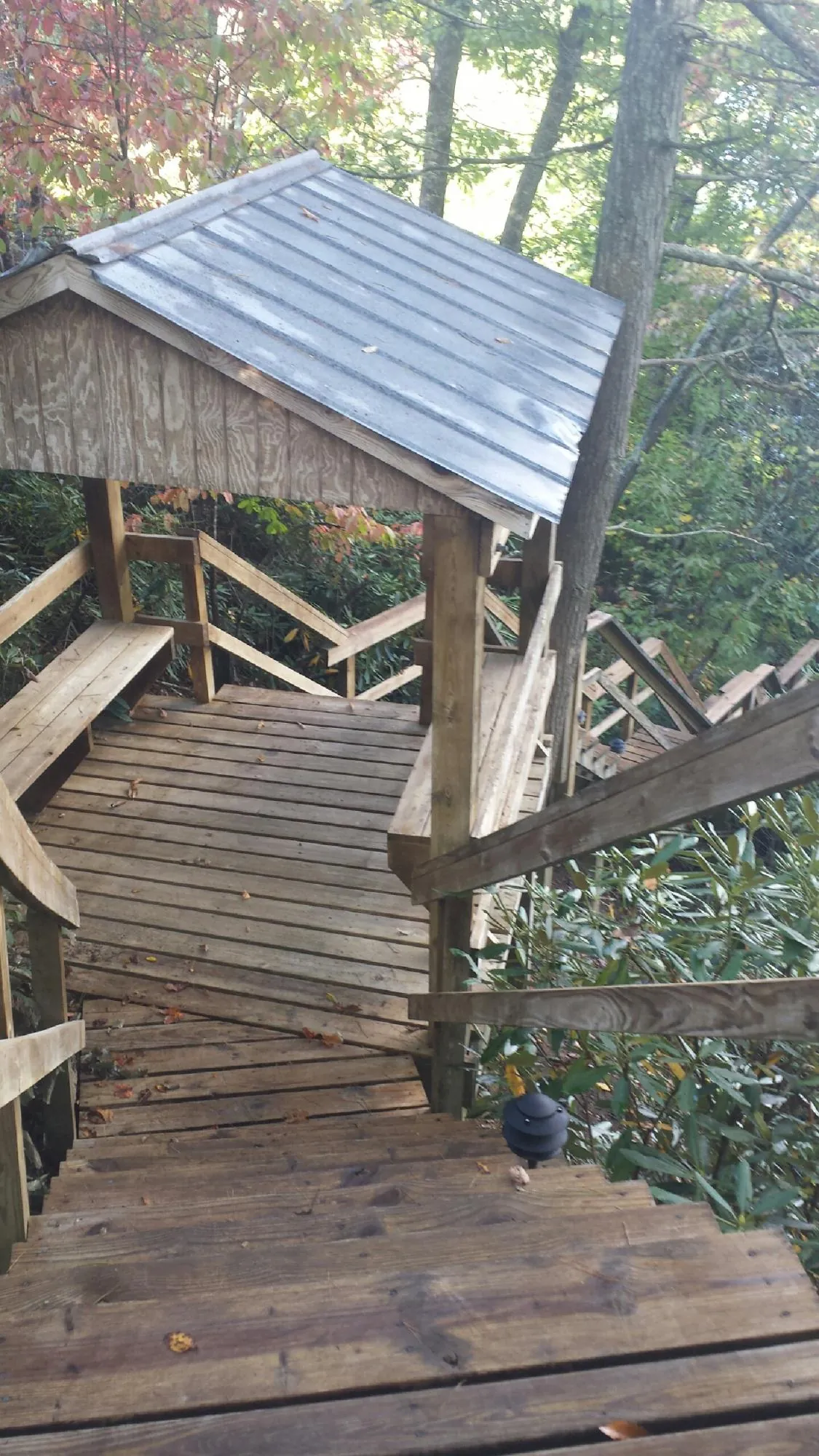 Metal roofed shelter over wooden steps on a wooded walkway — Skylight Repair & Installation work by our crew in Monsey