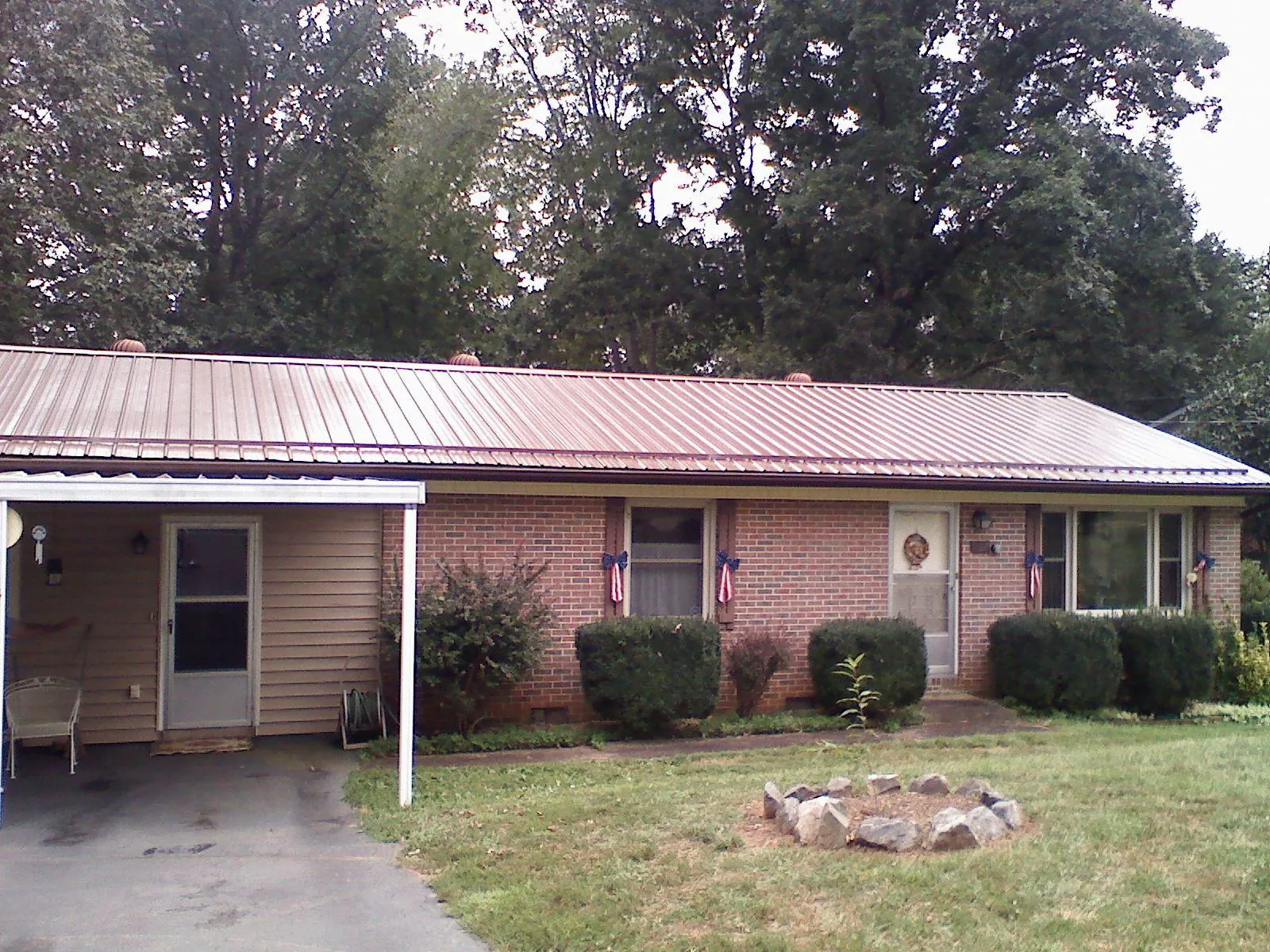 Bronze metal roof and carport on a brick ranch home — Roof Repair work by our crew in Monsey